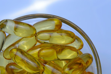Fish oil capsules on a glass plate. A lot of vitamin omega 3. Close-up.