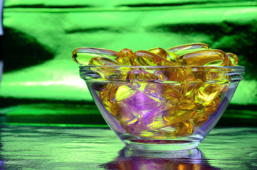 omega 3 capsule. In a glass bowl on a colored background.