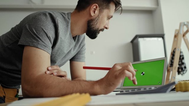 Video of carpenter doing calculations at the computer. Shot with RED helium camera in 8K