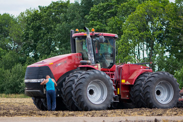 
tractor driver near a large red tractor illustrative editorial