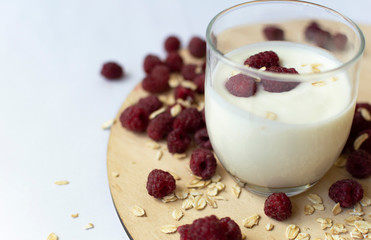 healthy snack with homemade yogurt, oat flakes and raspberry in the glass. Horizontal