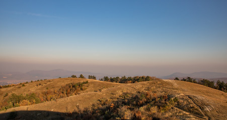 Naklejka premium Hills of Nagy-Séznás, a Hungarian mountain just before sunset, with lots of yellow grass everywhere,