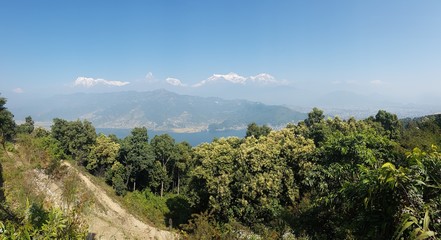 Obraz premium Panoramic view on Phewa Lake from World Peace Pagoda in Pokhara, Nepal. In the back there are high, snow capped Himalayan chains, with Mt Fishtail (Machhapuchhare) between them. Serenity and calmness