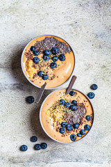 Vegan breakfast - chocolate smoothie bowl with chia pudding, peanut butter and berries in gray bowl.