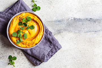 Sweet potato hummus or pumpkin dip in a gray bowl, top view.
