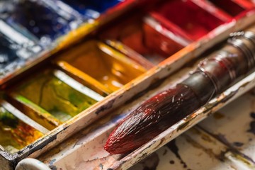 Set of watercolor paints and paintbrushes for painting closeup.