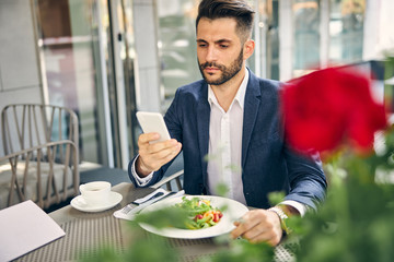 Attentive male person looking at screen of his gadget