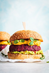 Vegan beetroot burger with sweet potato sauce and guacamole. Plant based diet concept.