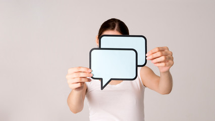 Woman shows sign speech bubbles. Speech bubble banner. Happy girl hold empty speech bubbles.