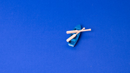 small wooden boat model on blue background