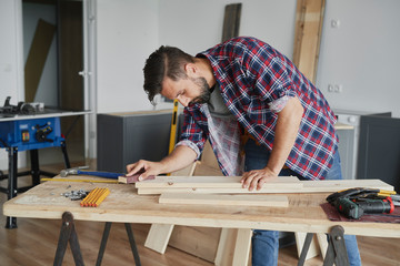 Carpenter cleaning the boards with sandpaper