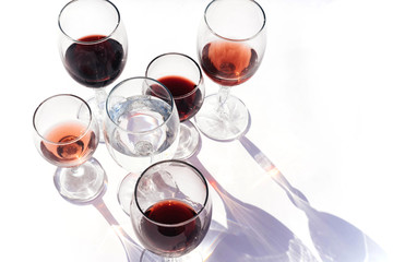 Wine of different varieties in glasses on a white background.