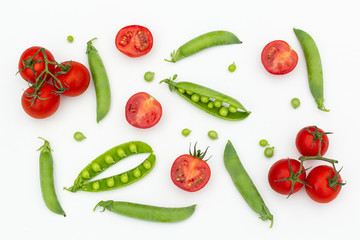 Red cherry tomatoes and green peas on white wooden table. Fresh summer vegetables for food concept, top view, flat lay, banner