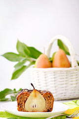 Piece of chocolate cake and a basket full of fresh pears with copy space