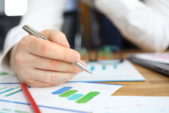 Man makes edits leaning over financial report