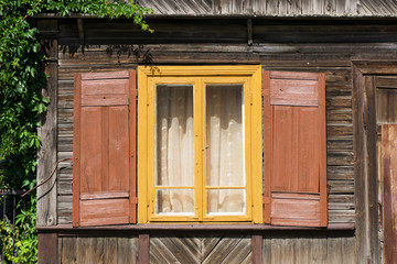 Wooden window rustic cottage house. Vintage wall with transparent glass window and decorative brown shutters. Countryside architecture historic building.