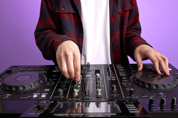 cropped dj man in white headphones behind dj console, makes song with dj controller. long haired caucasian guy in cool stylish wear posing on isolated background