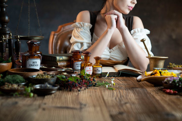 Natural medicine concept. Vintage pharmacist preparing natural medicament. Brass mortar and ...
