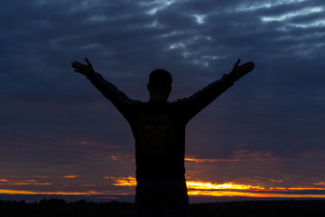 dark silhouette of a man on a sunset background