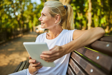 Beautiful woman using tablet computer on the street