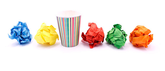 Colored wrinkled paper and paper cup, close up on white background