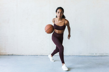 Obraz premium Photo of young african american sportswoman working out with basketball