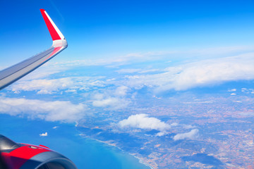 Aircraft wing and engine during the flight . Flying over the coastline 