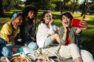 Image of student girls taking selfie on mobile phone and eating pizza