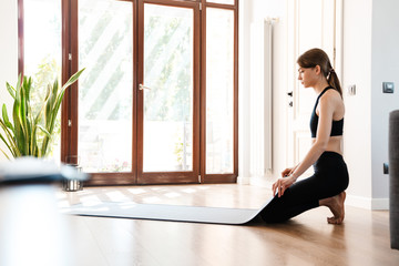 Fototapeta premium Attractive young woman working out at home