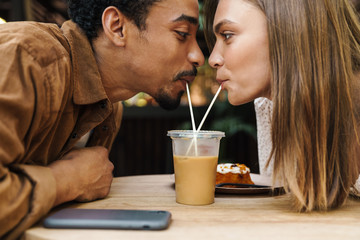 Image of romantic multinational couple drinking coffee together