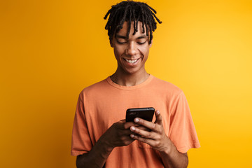 Fototapeta premium Young happy african man with cellphone isolated