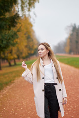 Closeup portrait of stylish blonde confident girl wth long hair wearing white shirt, black jeans,...