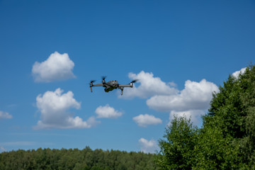 Fototapeta na wymiar Drone quadcopter in flight over the land