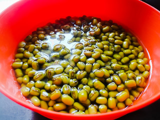 Green gram placed in soaked condition for sprouting in an orange bowl.