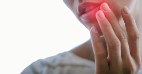 Woman with cold sore touching lips. Beautiful lips virus infected herpes. 
