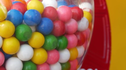 Colorful gumballs in classic vending machine, USA. Multi colored buble gums, coin operated retro dispenser. Chewing gum candies as symbol of childhood and summertime. Mixed sweets in vintage automate