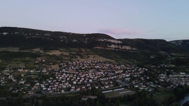 Aerial view of scenic romantic french city of a small historic town of Millau, France. Drone flying along beautiful french city nested among the hills and Tarn river flowing through the city.
