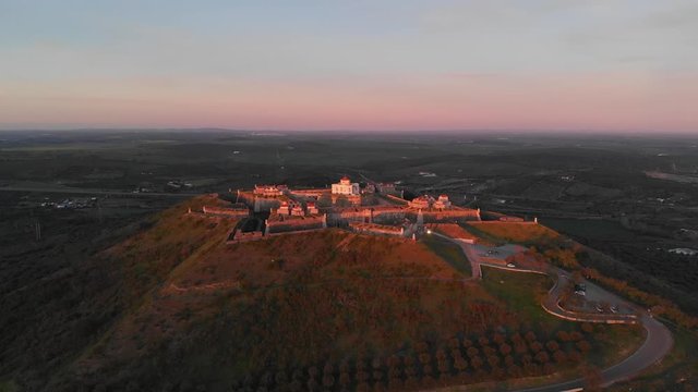 Rotating view of the Fort of Nossa Senhora da Graca catching the last light of the day with an orange glow.