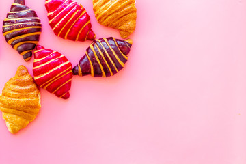 Set of croissants - chocolate, berry, classic - on pink desk top view