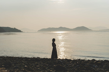 夕陽の海にいる女性