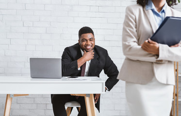 Sexual molesting. Perverted African American businessman ogling at his female subordinate in office