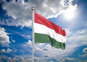 Realistic flag. 3D illustration. Colored waving flag of Hungary on sunny blue sky background.