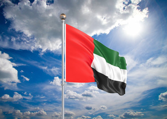 3D illustration. Colored waving flag of United Arab Emirates on sunny blue sky background.