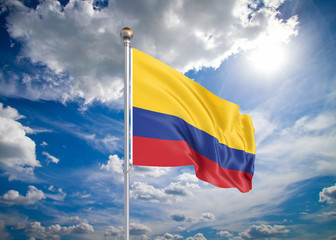 Realistic flag. 3D illustration. Colored waving flag of Colombia on sunny blue sky background.