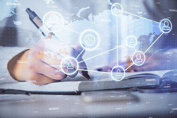 Social network theme hologram over hands taking notes background. Concept of global international people connect. Double exposure