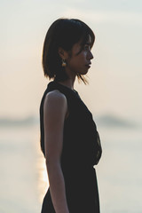 夕陽の海にいる女性