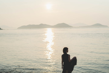 夕陽の海にいる女性