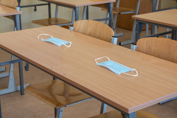 School desk in a school classroom with a face mask. School safety during a pandemic