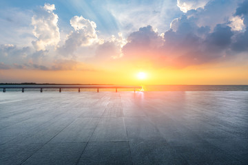 Empty square floor and lake with beautiful clouds at sunset.