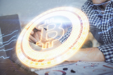 Blockchain theme hologram with man working on computer on background. Concept of crypto chain....